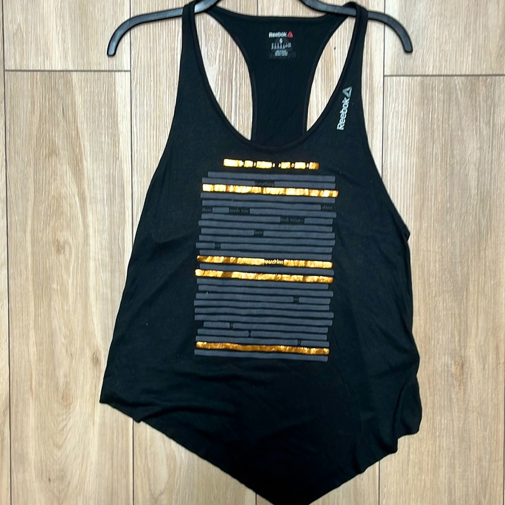 Looks sassy in this Reebok workout tank with gold accents